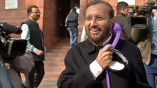<p>Prakash Javadekar talking into a purple receiver which is connected to his cell-phone.</p>