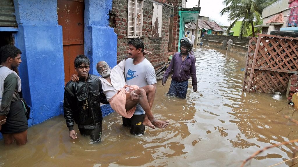 An elderly person is carried to a safe spot in a flooded locality following  heavy rains at Nagercoil in Kanyakumari district.