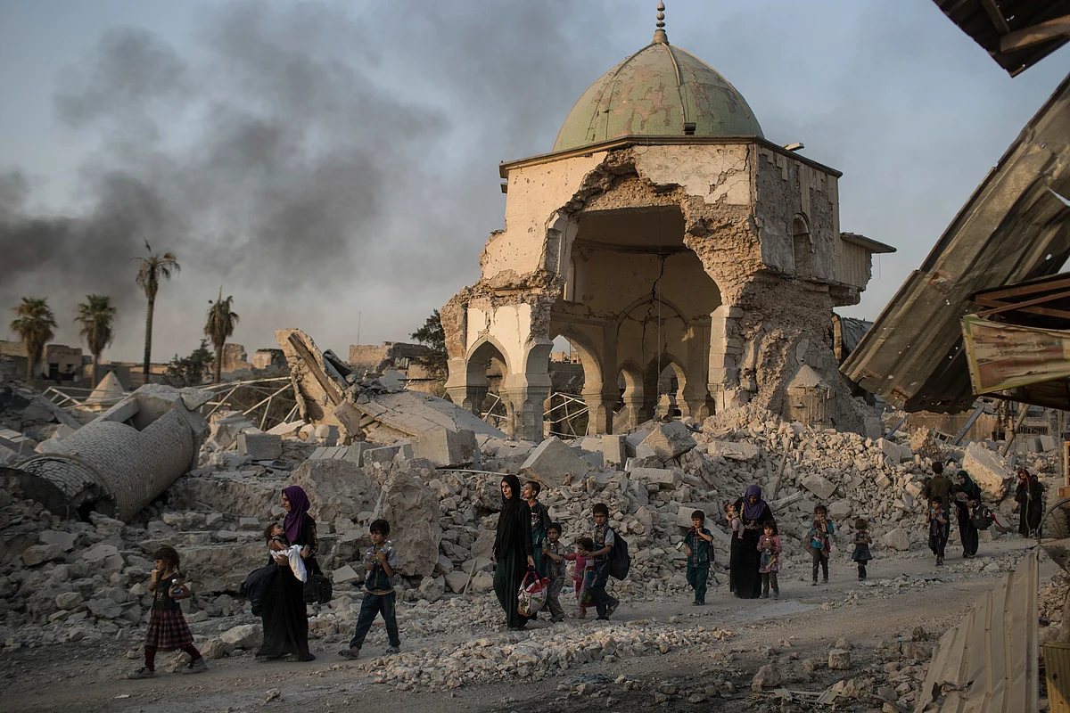 Iraqi civilians walk past the destroyed al-Nuri mosque as Iraqi forces continue their advance against ISIS militants in Mosul, in this file photo from 4 July 2017.