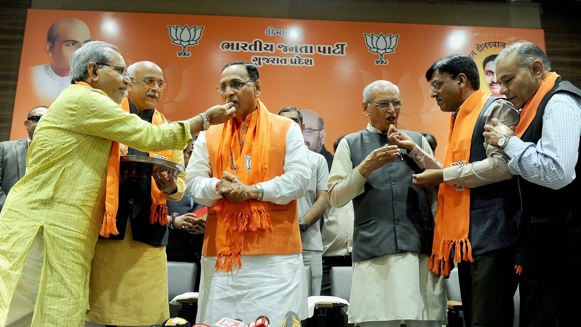 <p>BJP leaders offering sweets to incumbent Chief Minister Vijay Rupani after the party’s win in the state Assembly election.</p>