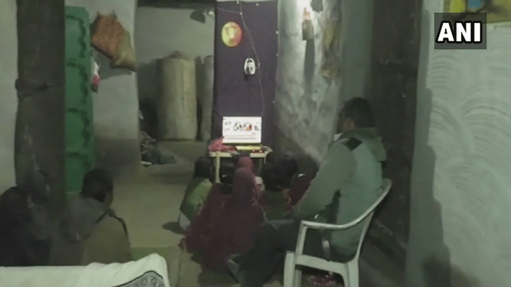 The people of Jokapath  watch television at their home after electricity has graced the village for the first time since 1947.