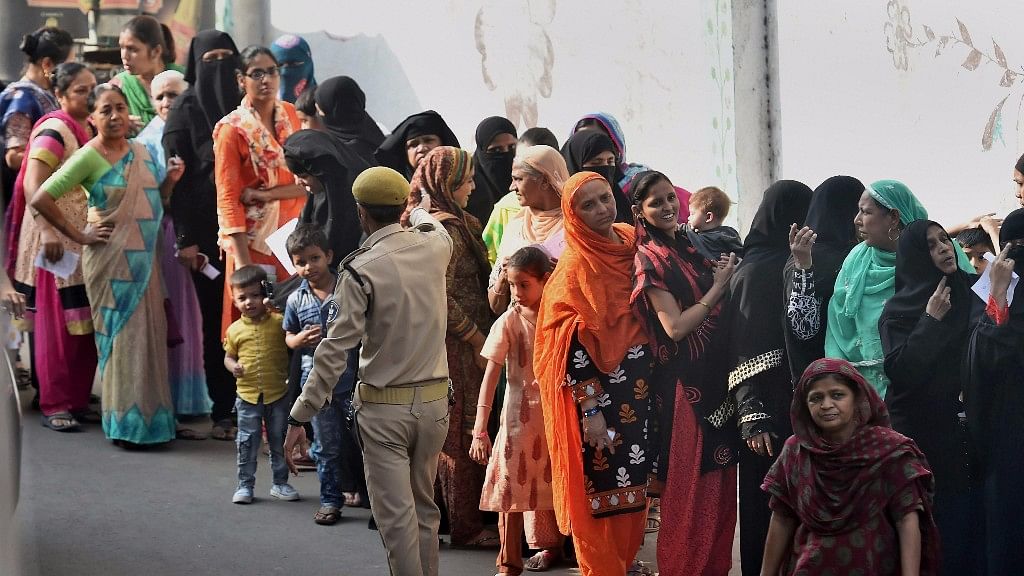 Woman voters wait in a long queue to cast their votes for the second phase of assembly elections at Daryapur, Ahmedabad on Thursday.