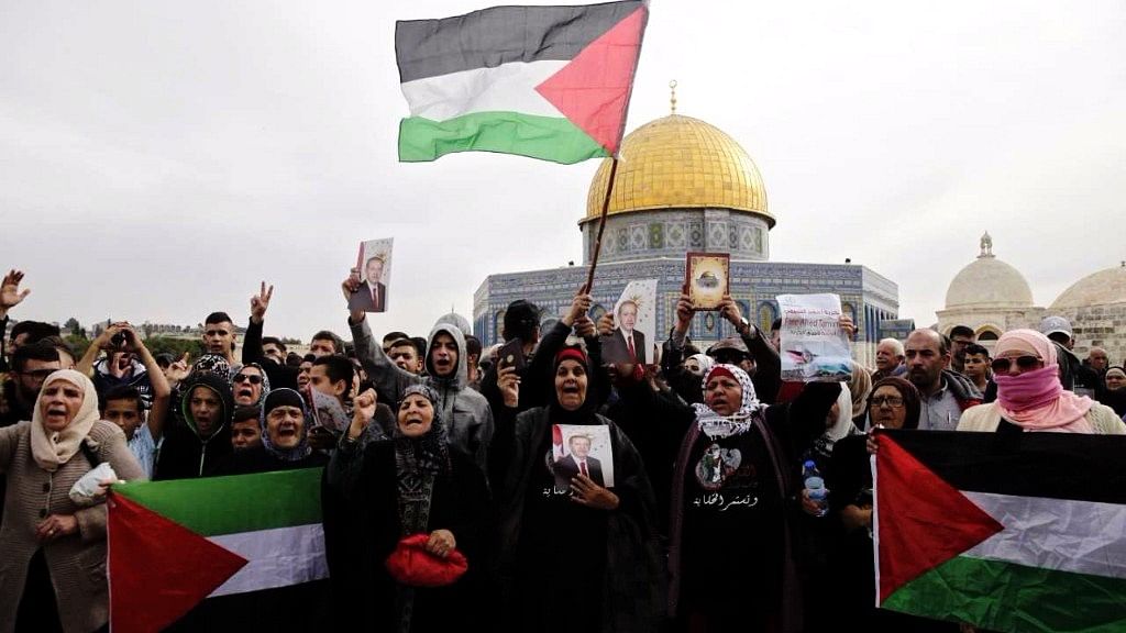 Palestinian women chant slogans and hold flags during a demonstration near the Dome of the Rock Mosque in the Al Aqsa Mosque compound in Jerusalem’s old city.