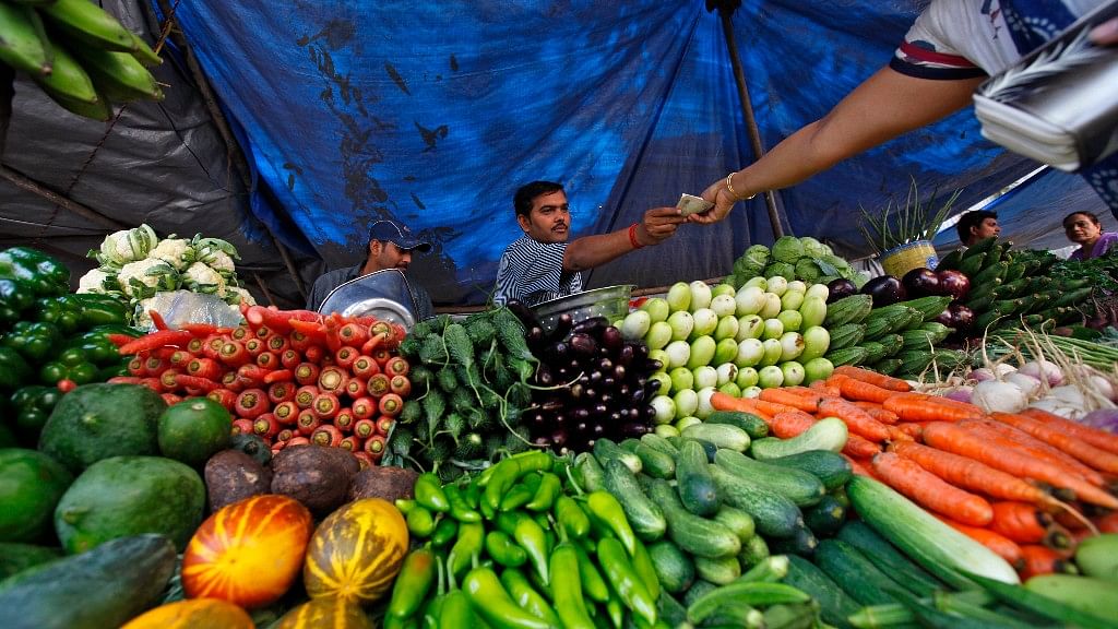 A customer pays after buying vegetables from a street side vendor in Mumbai.&nbsp;