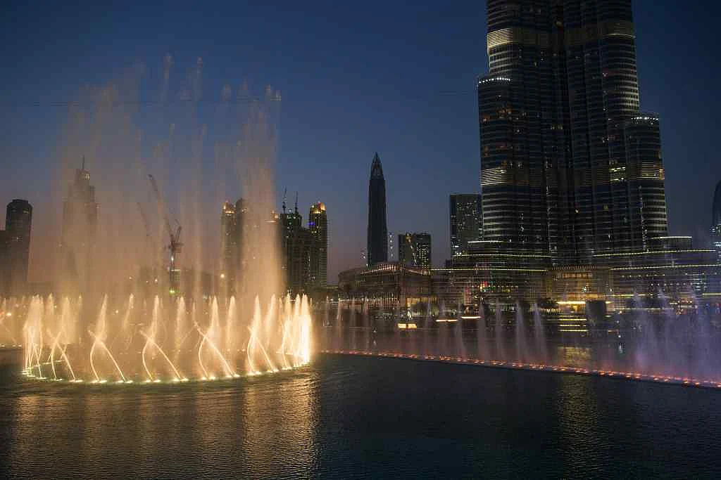 Lights illuminate a water fountain show outside the Dubai Mall at the base of the Burj Khalifa tower, right, in Dubai