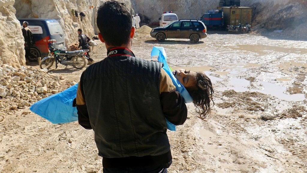 Man carries the body of a dead child, after what rescue workers described as a suspected gas attack in the town of Khan Sheikhoun in rebel-held Idlib, Syria.