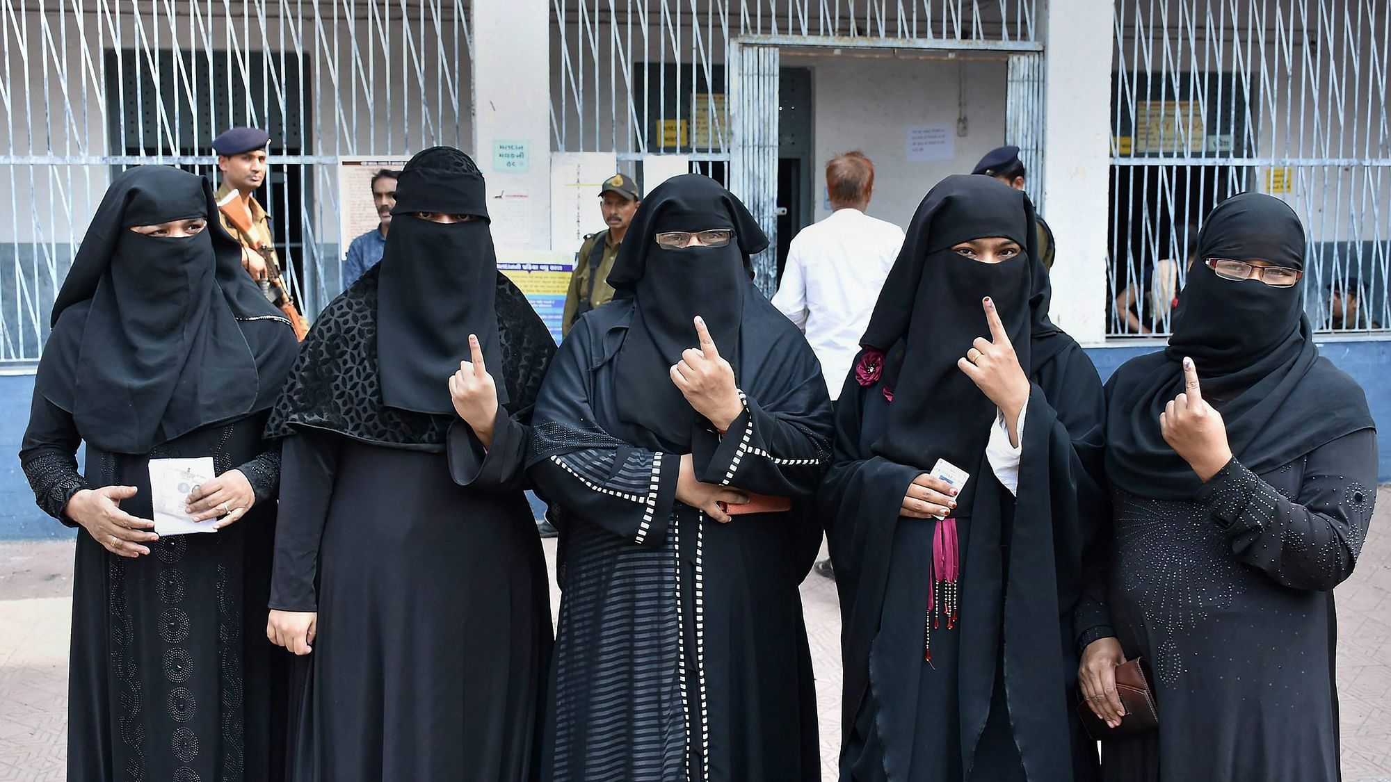 Muslim voters showing their inked fingers at a polling booth during Gujarat Assembly election in Surat.