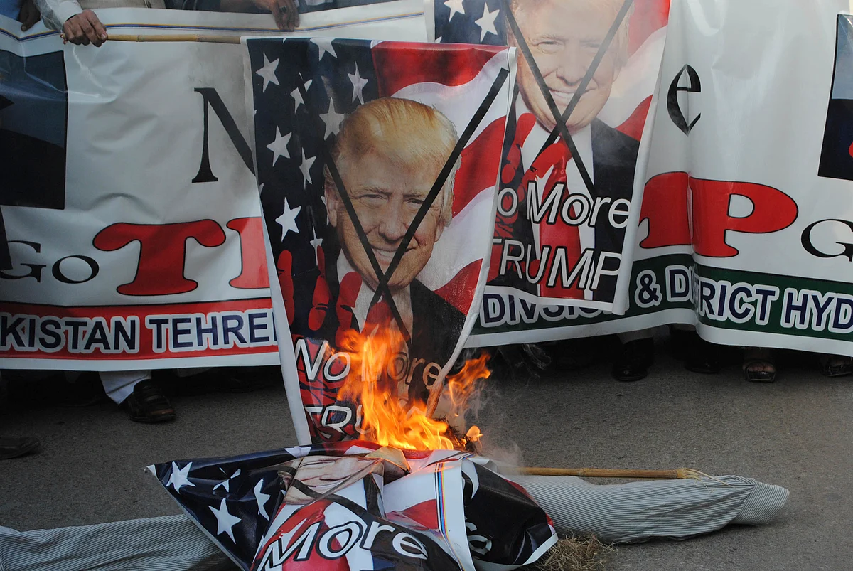 Pakistani protesters burn banners showing Donald Trump in Hyderabad, Pakistan.