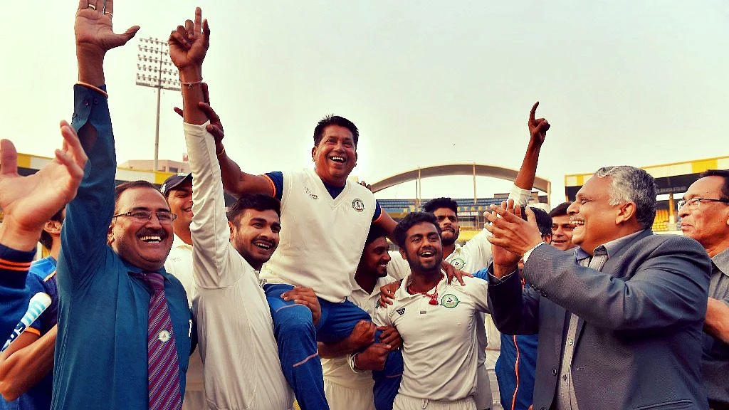 Vidarbha players celebrate with their coach Chandrakant Pandit after winning the Ranji Trophy final cricket match against Delhi by 9 wickets.