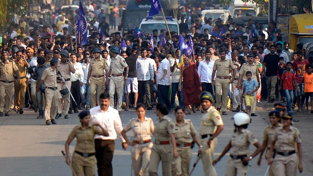 Policemen accompany protesters staging a demonstration in Mumbai on 2 January against the violence in Bhima Koregaon in Pune district.