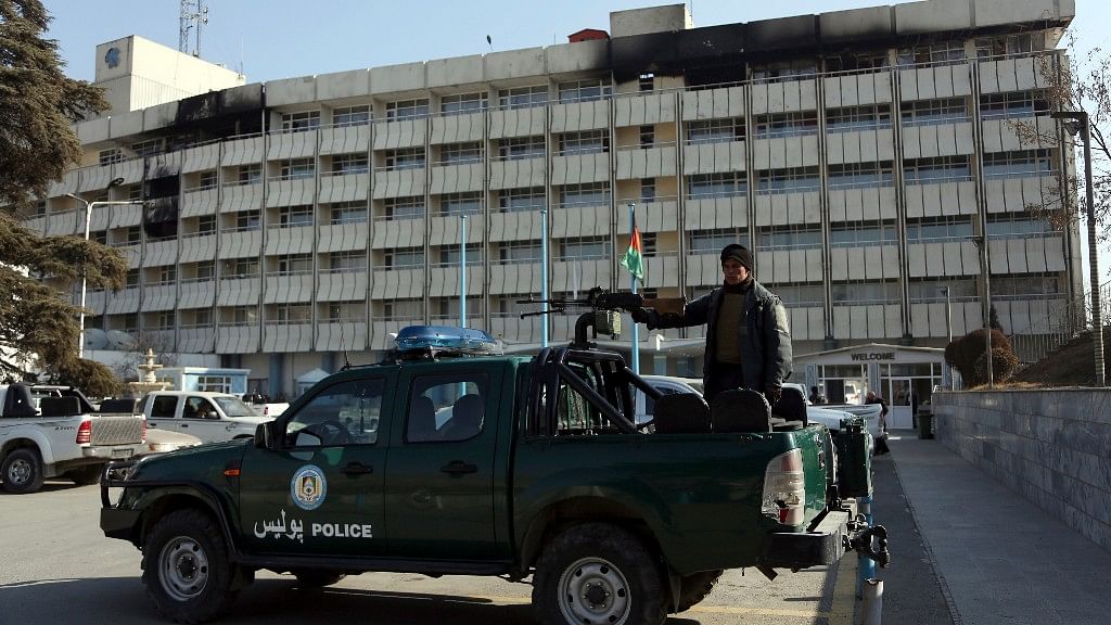 An Afghan police officer stands guard in front of the Intercontinental Hotel in Kabul, Afghanistan.