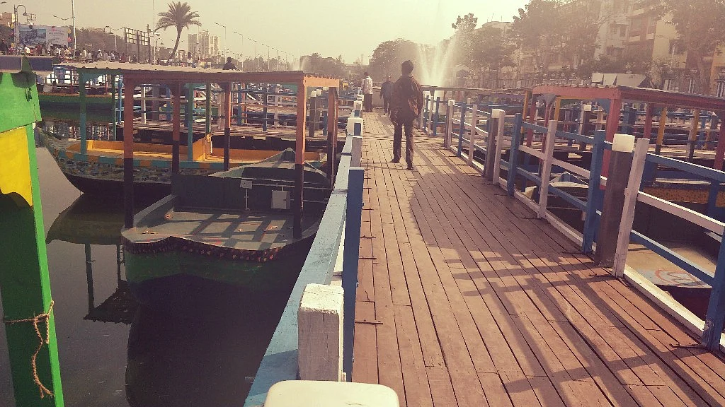 People use a wooden walkway to access the boats.