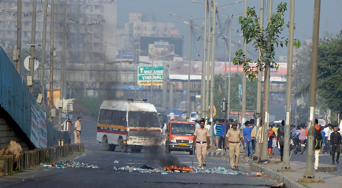 Policemen in Mumbai try to control the situation after a violent protest by Dalits over the Bhima Koregaon unrest.