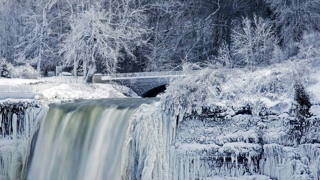 Visitors take photographs at the brink of the Horseshoe Falls in Niagara Falls
