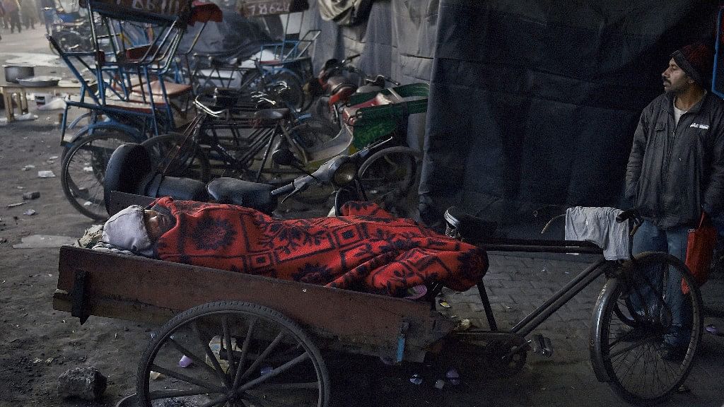 A man sleeping on a rickshaw in Delhi.&nbsp;