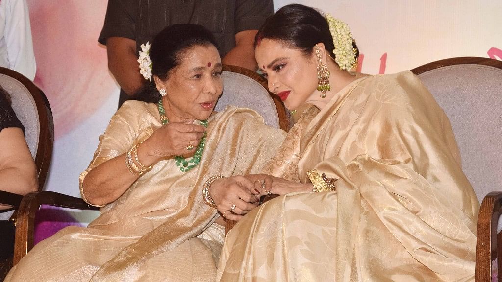Twinning in gold, Asha Bhosle shares a moment with Rekha.&nbsp;