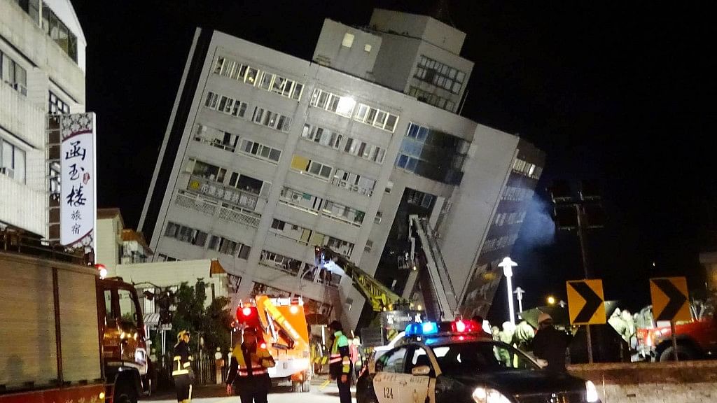 Rescuers are seen entering a building that collapsed onto its side from a 6.4 magnitude earthquake in Hualien County, eastern Taiwan.
