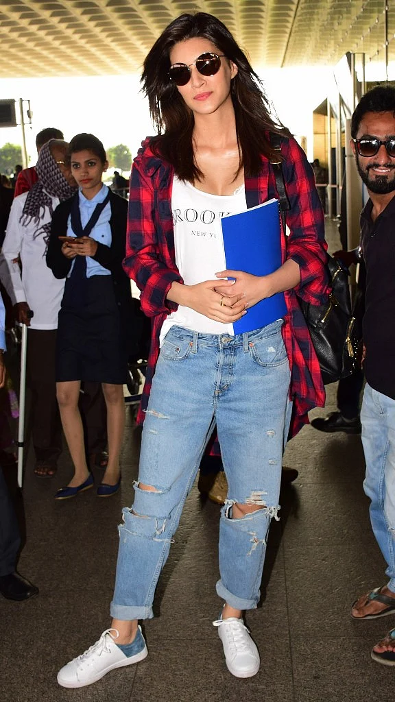 Kriti Sanon the style icon of Bollywood was spotted in a funky look with a classy touch. The ripped jeans paired with the white tank top and the checks shirt can never go out of fashion. Kriti fled to Chandigarh to start her new project <i>Arjun Patiala.</i>