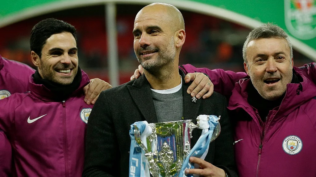 Manchester City’s manager Pep Guardiola (centre) poses with the trophy after his team won the English League Cup defeating Arsenal 3-0 in the final on Sunday.