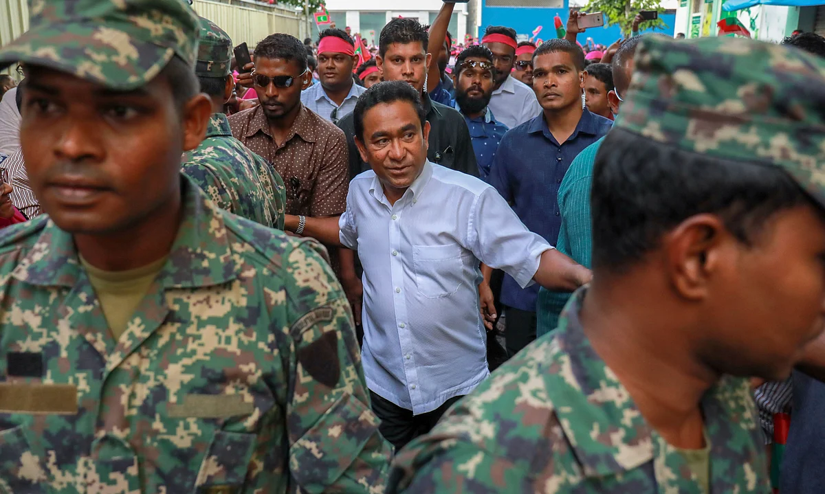 Maldivian President Yameen Abdul Gayoom, center, surrounded by his bodyguards arrives to address his supporters in Male, Maldives. 
