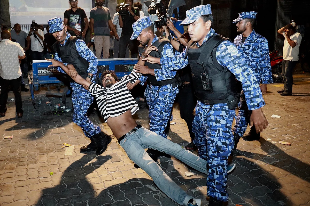 Maldivian police officers detain an opposition protestor.