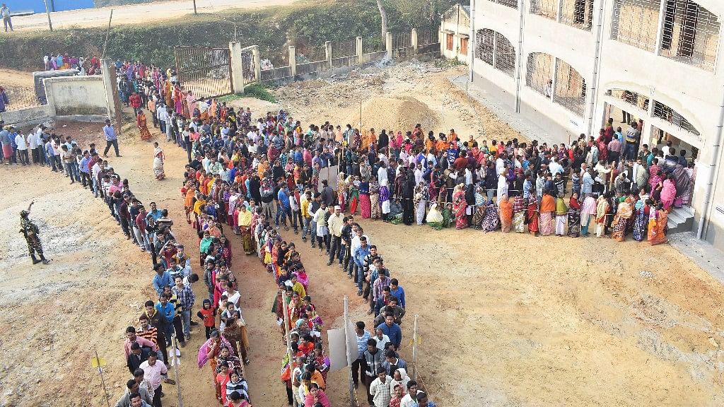 People wait in a queues to cast their votes for the Tripura Assembly Election in Agartala on 18 February.