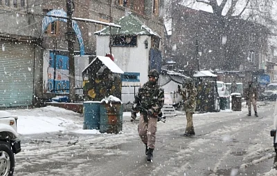 Srinagar: CRPF personnel conduct search operations amid snowfall after two militants were spotted by an alert sentry at the observation post of 23rd battalion of the CRPF in Karan Nagar area of Srinagar on Feb 12, 2018. The two were forced to flee as the alert sentry fired at them. Searches in the area revealed that the militants, carrying backpacks and AK-47 rifles, had taken shelter in a building near the CRPF camp, which was then surrounded. (Photo: IANS)