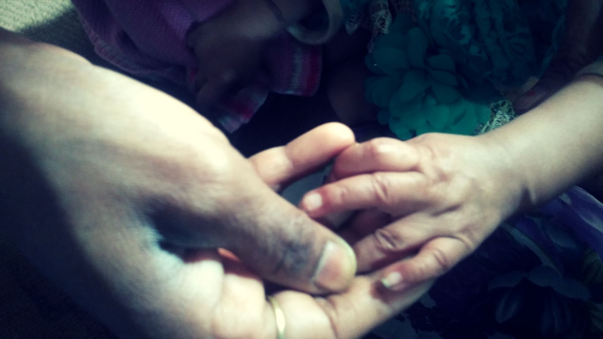 The 8-month-old who was raped by her cousin holds her mother’s hand.&nbsp;