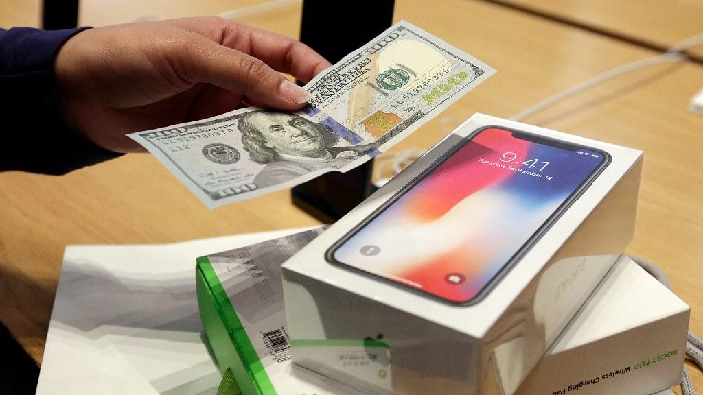 A customer hands over cash as she pays for an iPhone X at the Apple Store on New York’s Fifth Avenue. Image used for representation.