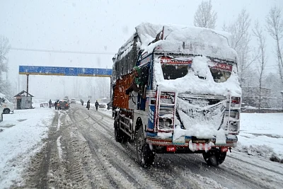 Qazigund: A truck driver enjoys the snowfall even as vehicular movement was affected after the Jammu-Srinagar highway was closed due to heavy snowfall; in Qazigund of Jammu and Kashmir