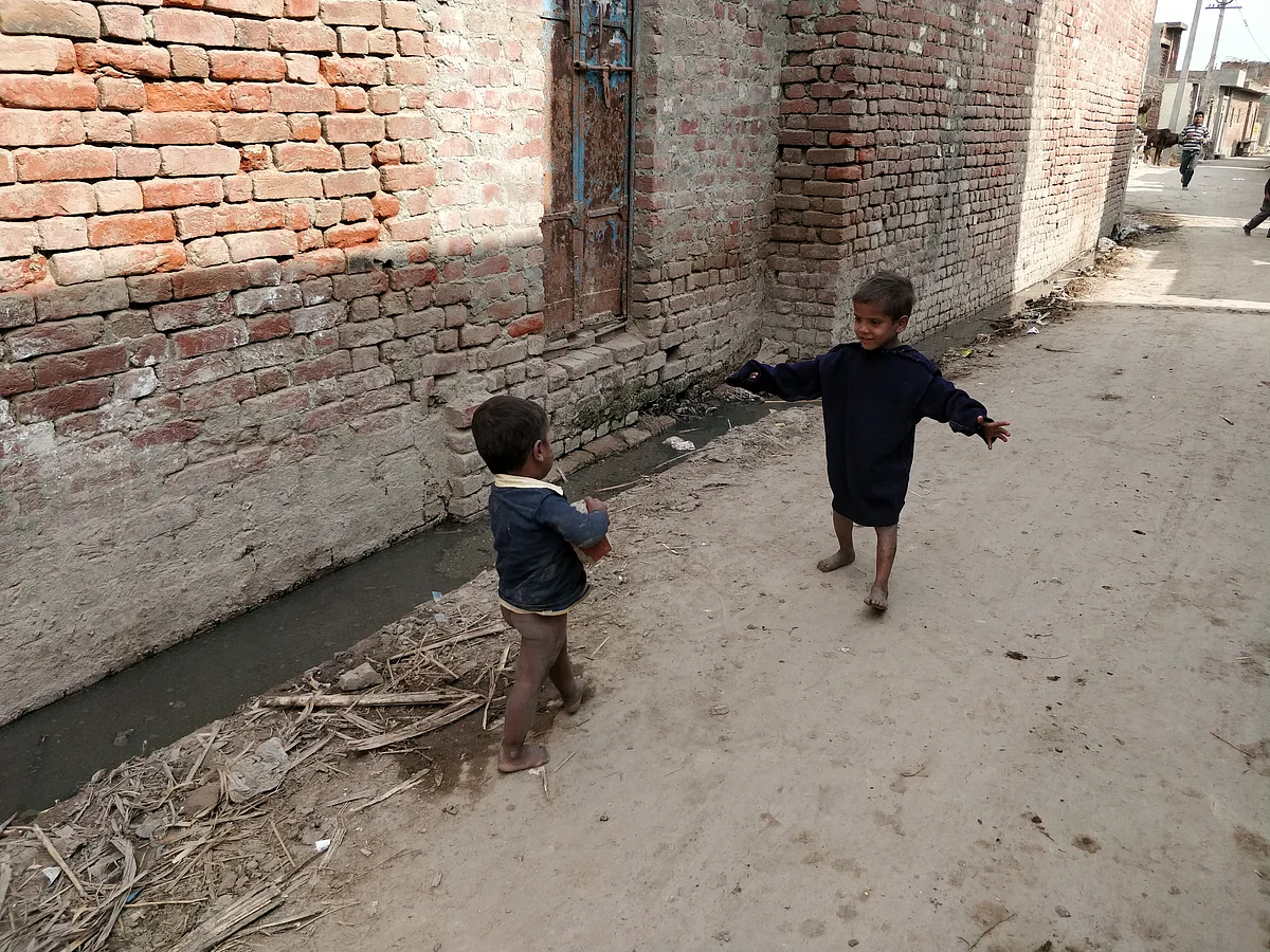 Dirty, clogged drains and human faeces, around which children play, greet visitors on their way to Kadarbadi village.