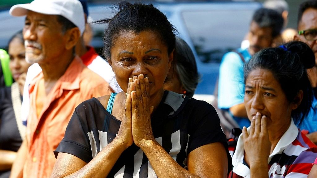 Relatives wait to hear news about the fate of detained prisoners at a police station where a riot broke out, in Valencia, Venezuela.