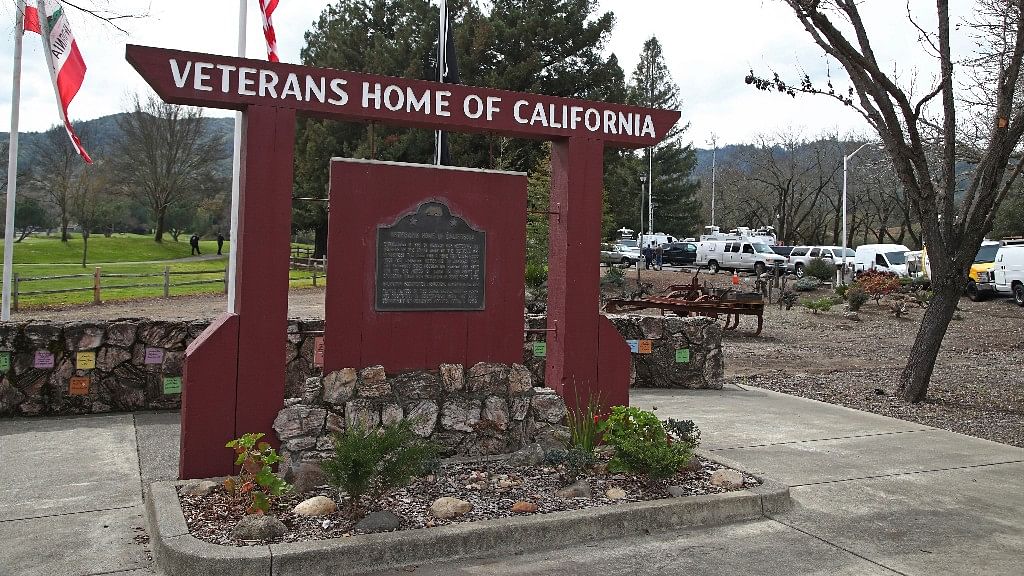 Media trucks stage at the entrance to the Veterans Home of California