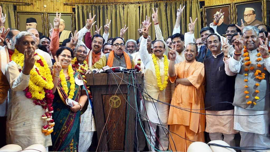 Uttar Pradesh Chief Minister Yogi Adityanath flashes the victory sign with newly elected BJP MPs of Rajya Sabha after BJP wins 9 seats in UP, in Lucknow.&nbsp;