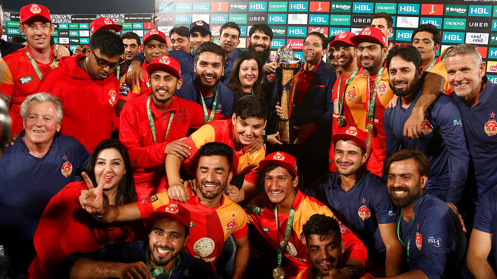 Officials and players of Islamabad United cricket team pose with winning trophy of Pakistan Super League at National stadium in Karachi.