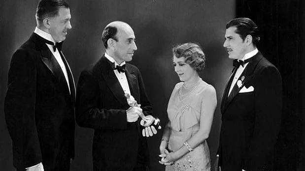  William C Demille, President of The Academy of Motion Picture Arts and Sciences, presenting an Oscar to Mary Pickford, as Warner Baxter and Hans Kraly look on, at the first Oscars ceremony in 1929.