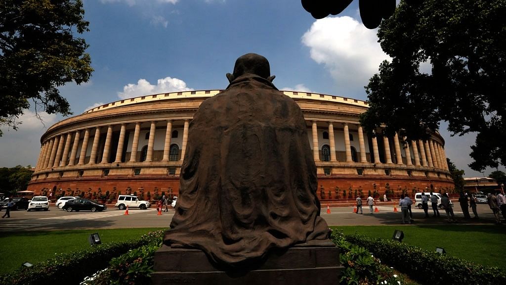 A statue of Mahatma Gandhi overlooks the Indian Parliament house.&nbsp;