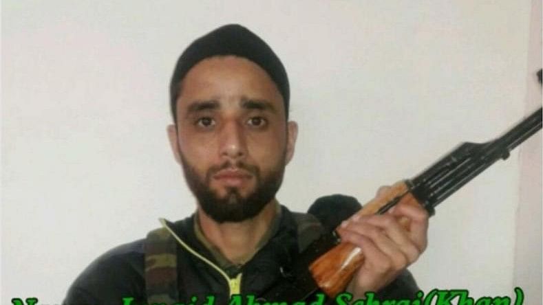 A photo of Junaid Ashraf holding an AK 47 assault rifle and wearing an armor vest went viral on social media.