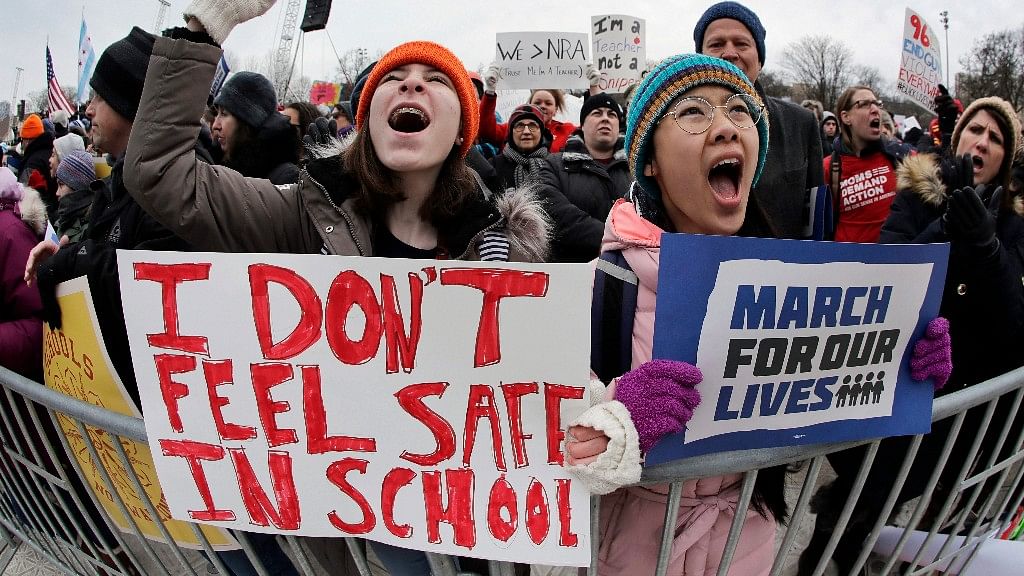 Demonstrators hold signs during a “March for Our Lives” rally in support of gun control, on 24 March in Chicago.&nbsp;