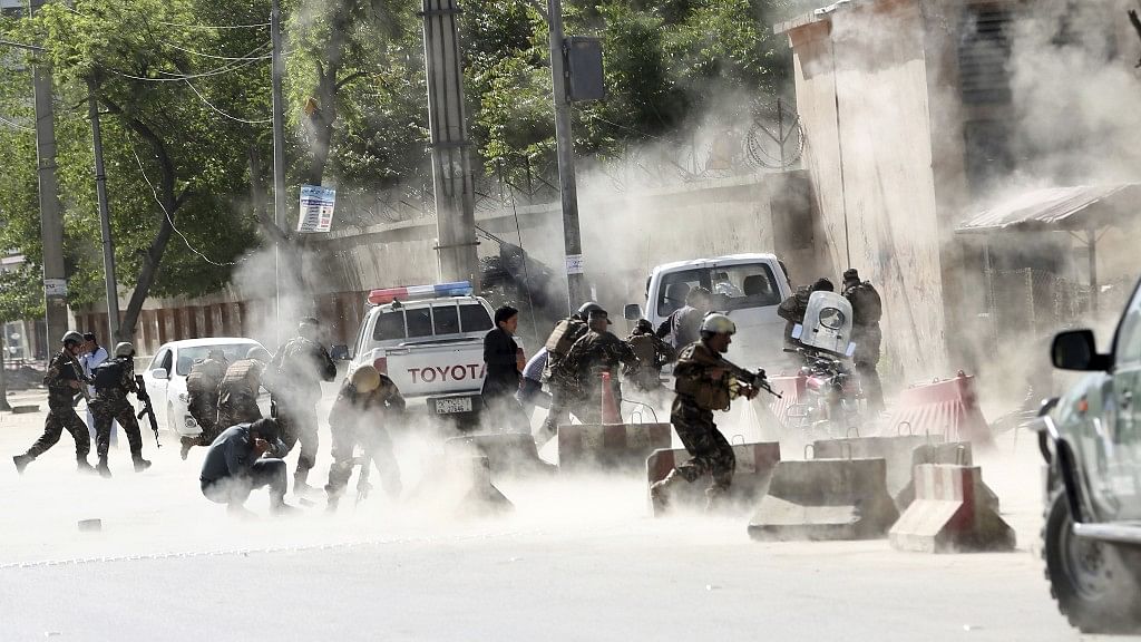 Security forces run from the site of a suicide attack after the second bombing in Kabul, Afghanistan, Monday, 30 April 2018.
