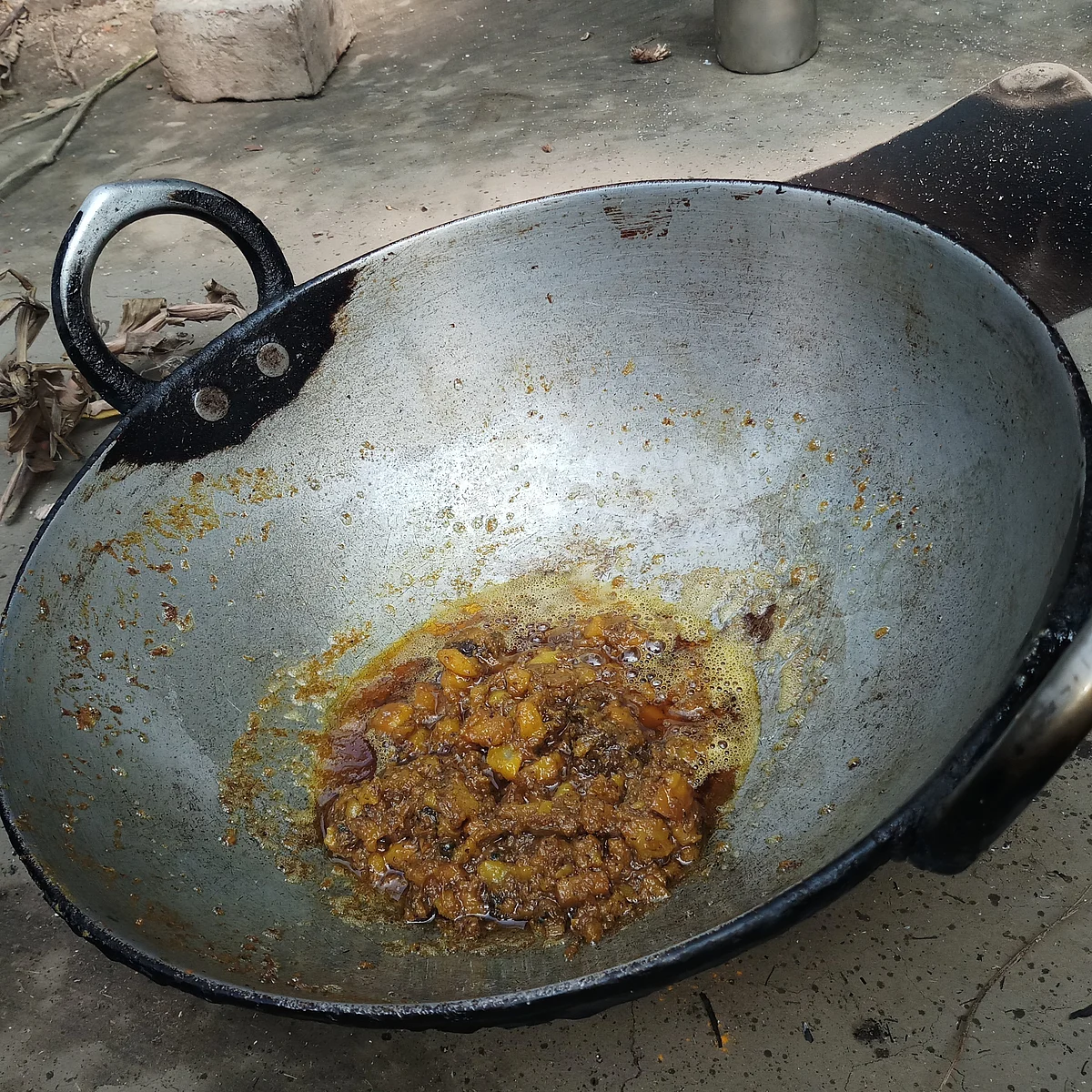 After cooking the Googli for 20 minutes, she removes the kadhai from the oven.
