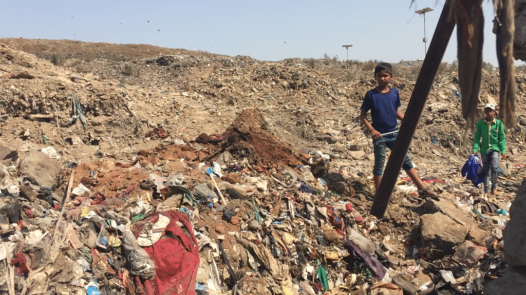Children enter the Deonar dumping ground through a broken boundary wall.