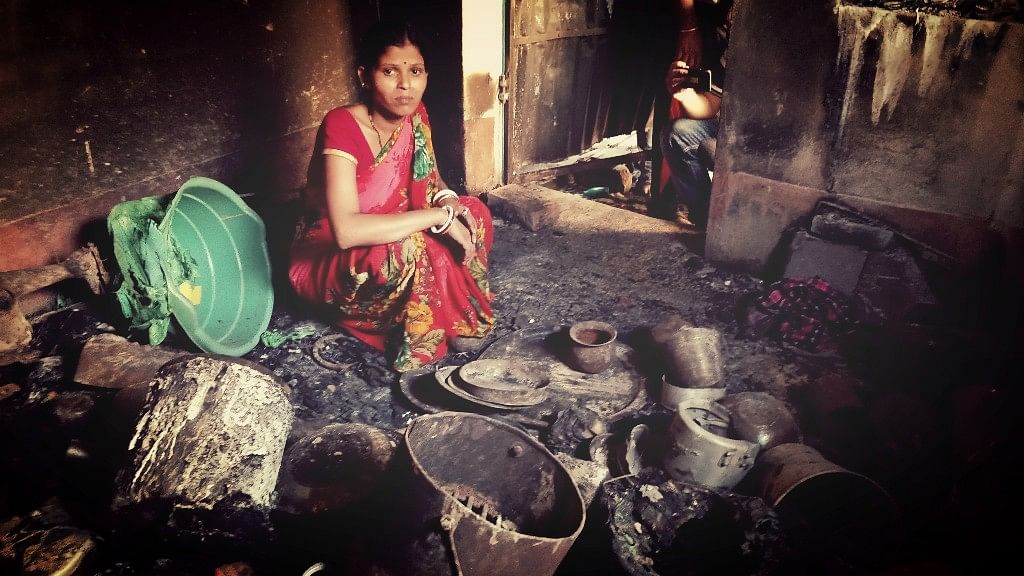 A woman in Asansol’s Chandmari area sits on the burnt remains of her home.