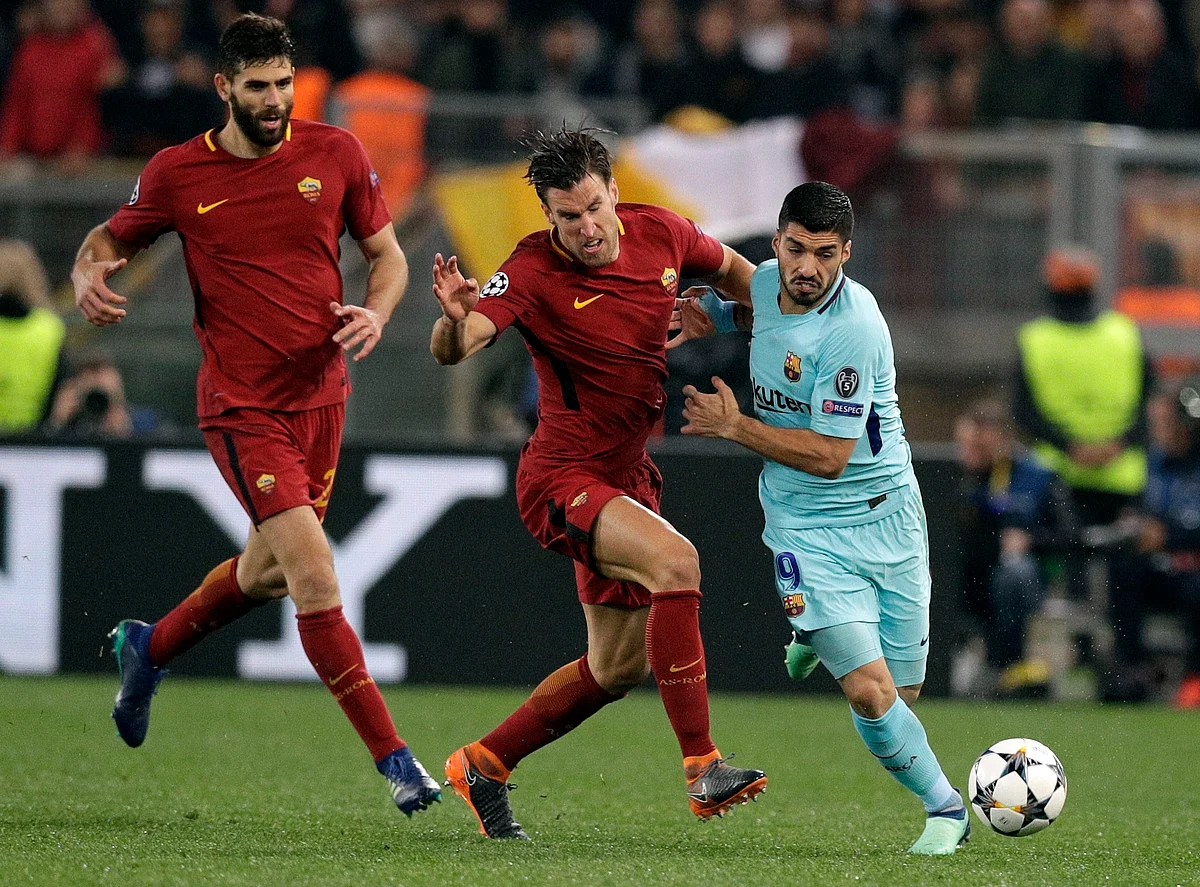 Barcelona’s Luis Suarez, right, is challenged by Roma’s Kevin Strootman during the Champions League.