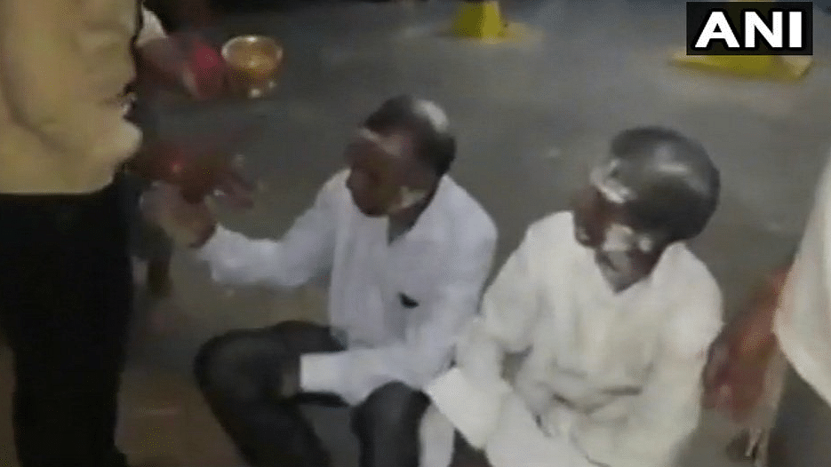 The video shows the two pastors sitting on the floor of the temple while a man smears their faces with  ash.