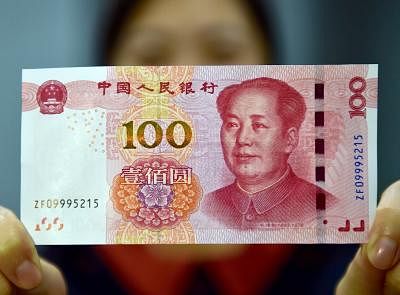 BEIJING, Nov. 12, 2015 (Xinhua) -- A resident displays a new 100-yuan banknote in Beijing, capital of China, Nov. 12, 2015. China