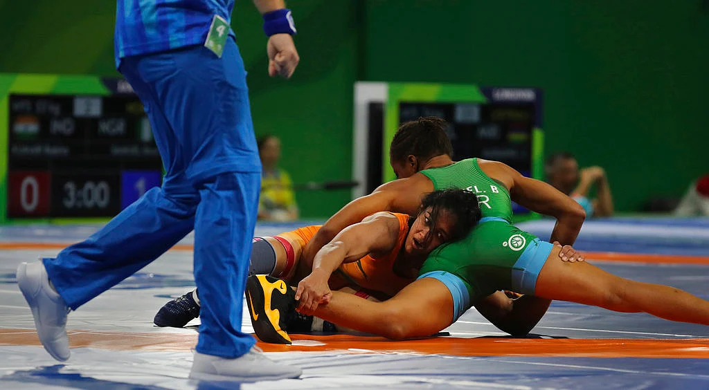 India’s Babita Kumari, center, wrestles against Nigeria’s Bose Samuel.