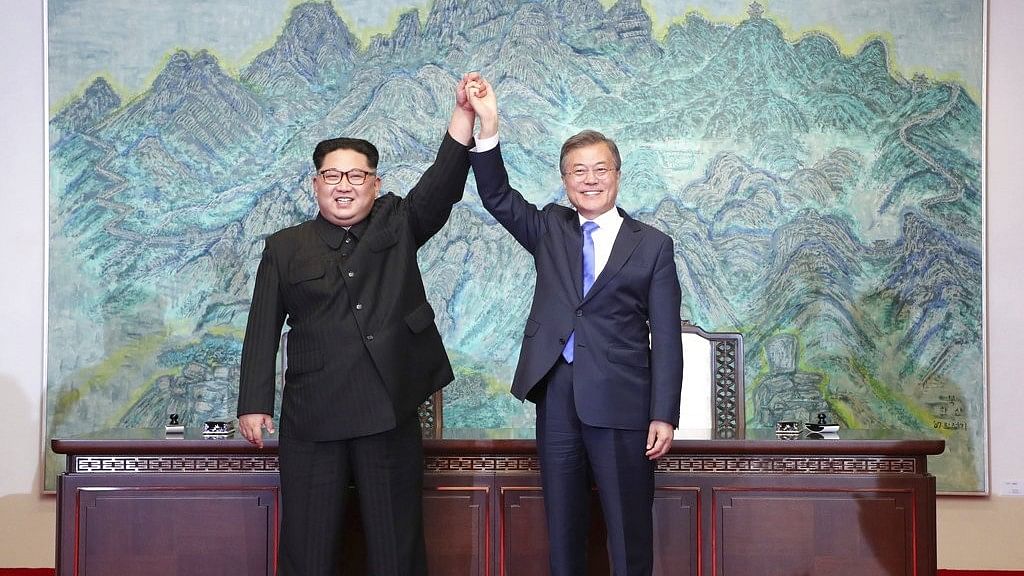 North Korean leader Kim Jong Un, left, and South Korean President Moon Jae-in raise their hands after signing on a joint statement at the border village of Panmunjom in the Demilitarized Zone, South Korea, Friday, April 27, 2018.