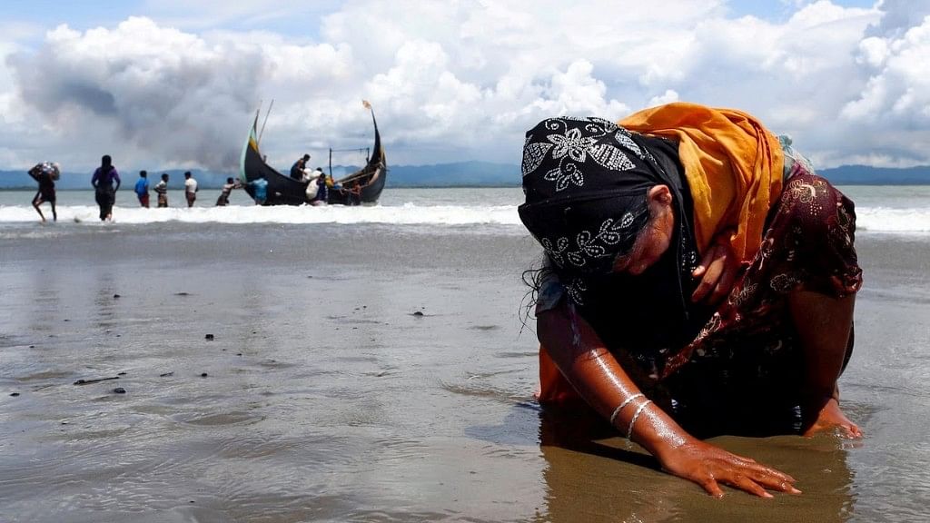 An exhausted Rohingya refugee woman touches the shore after crossing the Bangladesh-Myanmar border by boat through the Bay of Bengal. Siddiqui’s picture won a Pulitzer.&nbsp;