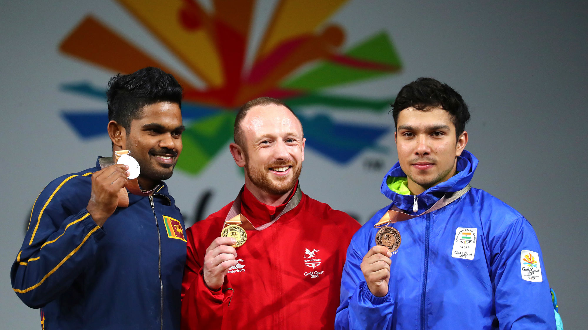 Wales’s men’s 69Kg Weightlifting Gold medalist Gareth Evans, center, stands with Sri Lanka’s Silver medalist Mudiyanselage Dissanayake, left, and India’s Bronze medalist Deepak Lather pose for the photographers after the medal ceremony at the Commonwealth Games, in Gold Coast, Australia